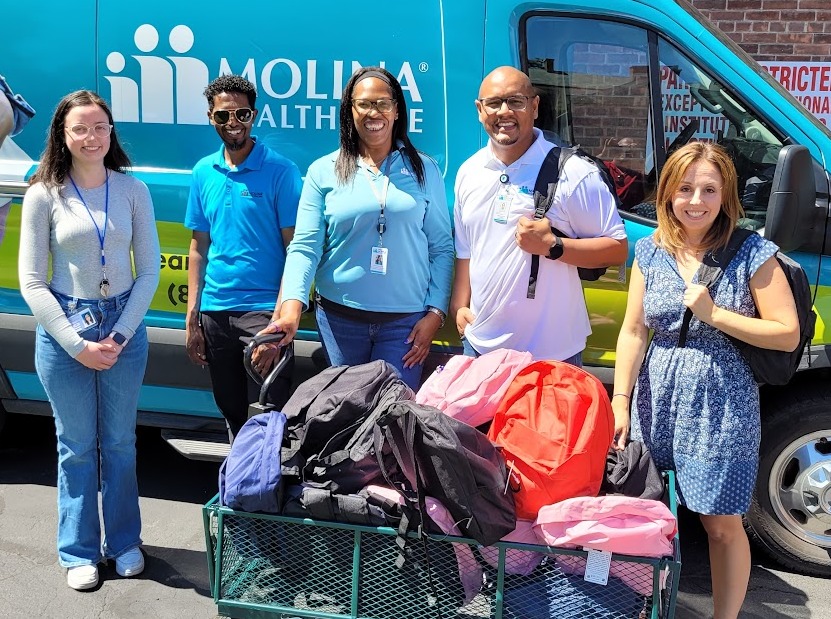 Molina Healthcare reps donating bookbags to IIB